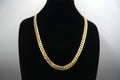 Gold chain necklace on a black mannequin against a white background