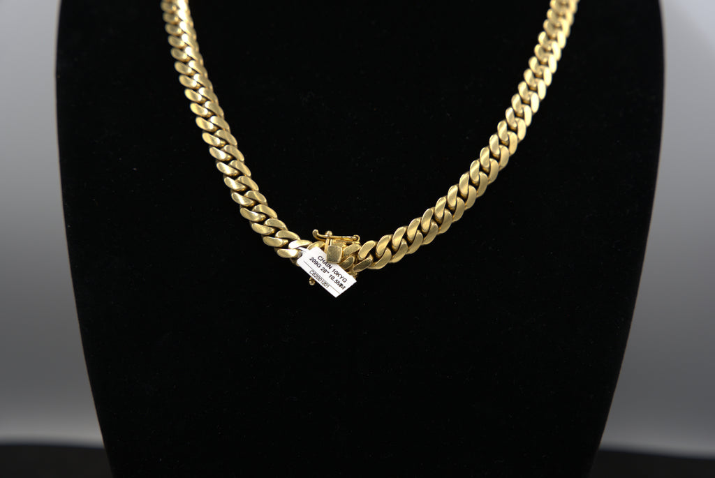 Gold chain necklace on a black mannequin bust with a neutral background