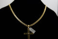Gold chain necklace with a cross pendant on a black background